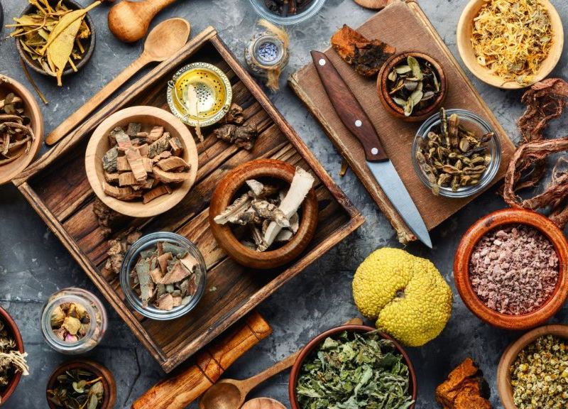 Dried healing herbs and roots in wooden bowls