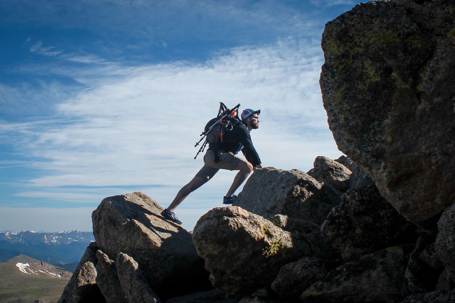 A hiker standing on a rocky summit
