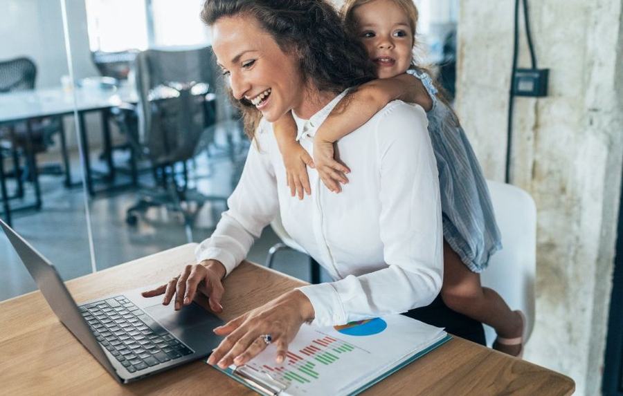 A mother learning at home with her child on her back